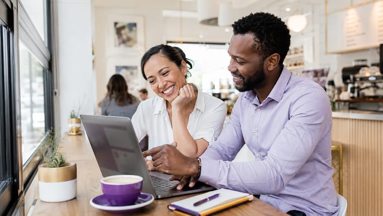Two marketing professionals working together at a laptop